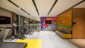A modern gym with treadmills, ellipticals, and a mirrored wall. - Hampton by Hilton Hangzhou Binjiang (Hangzhou)
