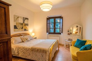 A bedroom with a bed, bedside table, dresser, and a window with a view. - OASIS THE PEARL APARTMENT - NATURAL POOL AND GYM (Passignano sul Trasimeno)