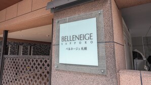 En skylt för Belleneige Sapporo med japansk text.