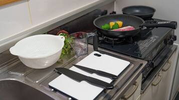 Appartement | Privékeuken | Een koelkast, een magnetron, een kookplaat, kookgerei, borden en bestek