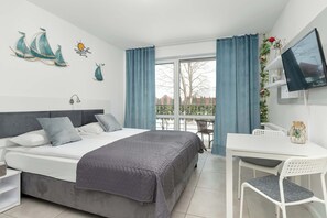 A modern bedroom with a bed, a desk, and a TV. - Cozy Studio in Jastrzębia Góra | Furnished Terrace (Jastrzębia Góra)