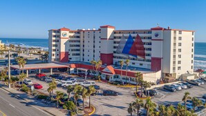A hotel with multiple floors, a parking lot, and a view of the ocean. - Harbour Beach Resort 219 (Daytona Beach)