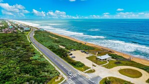 Vista aérea de una zona costera con carretera, playa y edificios.