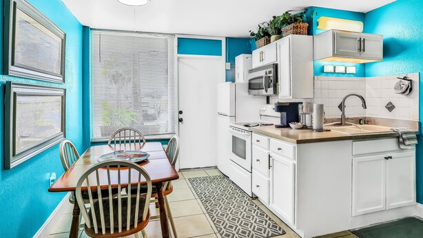 A compact kitchen with white cabinets, a microwave, and a sink. - Ocean Jewels Club 104 - Beach Jewel (Daytona Beach)