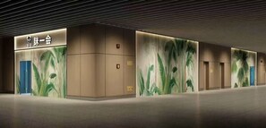 A modern hotel lobby with a reception desk, blue doors, and a large wall mural. - Take a nap hotel (Xianyang)