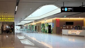 A modern indoor waiting area with a clear directional sign, a reception desk, and a clean, reflective floor. - Take a nap hotel (Xianyang)