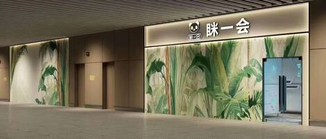 A modern lobby with a large panda logo and Chinese characters, indicating a themed establishment.