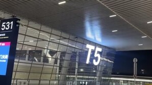 A modern indoor space with a prominent 'T5' sign, glass walls, and a ceiling with linear lighting fixtures. - Take a nap hotel (Xianyang)