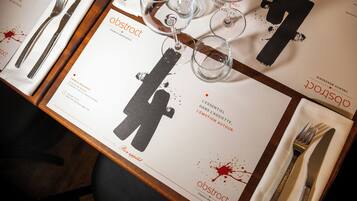 A table set with a menu, wine glasses, and cutlery.
