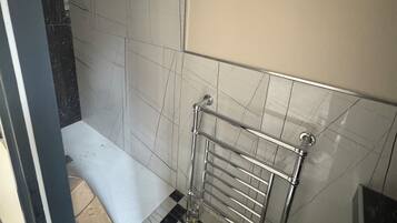 Badkamer | Een douche, een haardroger, handdoeken, zeep