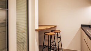 A kitchen with a wooden countertop and two stools. - Munich Finest Apartments Studio 11 by Interhome (Munich)