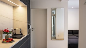 Eine moderne Küche mit Marmor-Spritzschutz, einer Obstschale und einer Kaffeemaschine.