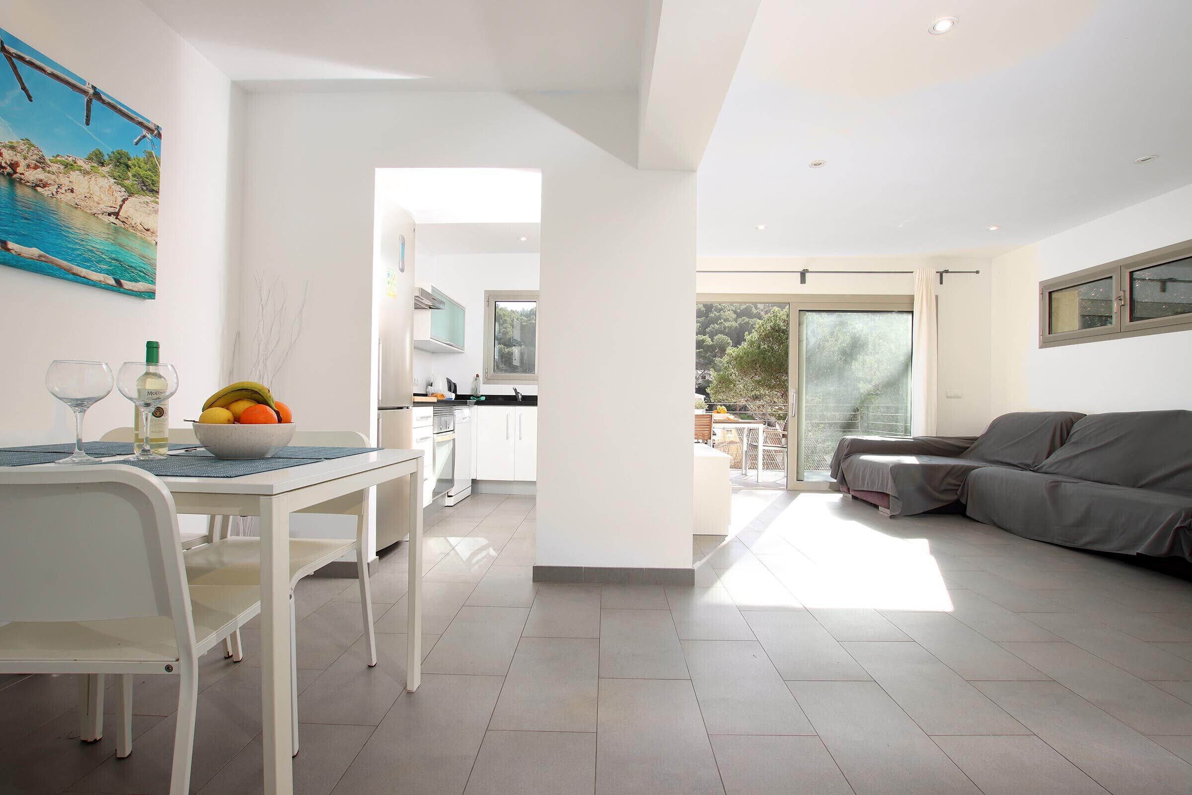 A modern living space with a dining area, kitchen, and a balcony with a view.