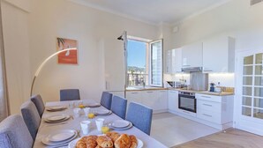 A modern kitchen with white cabinets, a built-in oven, and a window overlooking a cityscape. - Apartment in Cannes with 4 bedrooms sleeps 8 (Cannes)