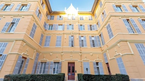 A multi-story building with a symmetrical facade, large windows with shutters, and a central entrance. - Apartment in Cannes with 4 bedrooms sleeps 8 (Cannes)