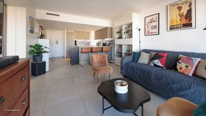 A modern living room with a sofa, a coffee table, and a kitchen in the background. - Apartment in Cannes with 1 bedrooms sleeps 4 (Cannes)