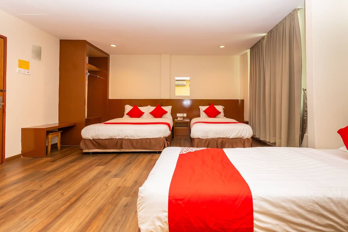 Une chambre d’hôtel avec deux lits, un bureau et une armoire.