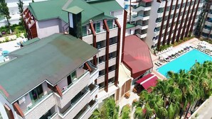 A multi-story hotel with a swimming pool, balconies, and palm trees. - Club Monte Carlo Hotel - All Inclusive (Alanya)