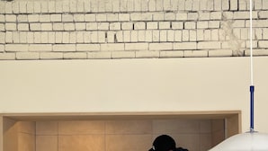 A small, enclosed space with a brick wall, a white ceiling, and a blue pendant light. - BOTANIK HOTEL (Cheonan)