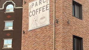A brick building with a sign reading "PARC COFFEE" and a directional arrow pointing to the right. - BOTANIK HOTEL (Cheonan)