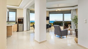 A modern interior with a kitchen, dining area, and a view of the sea. - Aqua Natura Villas - Villa Aqua (Rhodes)