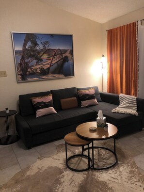 Ein Wohnzimmer mit einer Couch, einem Couchtisch, einem Gemälde und einer Lampe.