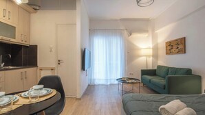 Una habitación de hotel funcional con kitchenette, comedor, sofá y cama.