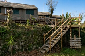A wooden staircase leading to a building with a covered entrance. - Safari Glamping Portugal Koi Fish (Ventosa)