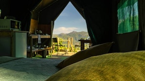 Une pièce confortable avec un lit, un bureau et une chaise, donnant sur un paysage montagneux.