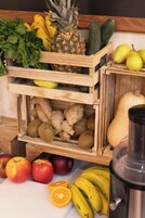 Wooden crates filled with fruits and vegetables, including apples, bananas, and ginger.