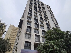 Un edificio alto y moderno con varios pisos, ventanas amplias y balcones.