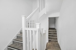 Una escalera con barandillas blancas y escalones de madera que conducen a una plataforma.