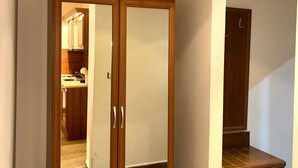 Ein Holzkleiderschrank mit Spiegeln, eine Holzbank und ein Fliesenboden.
