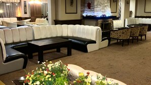 Eine großzügige Lobby mit Ecksofa, Kamin und einer dekorativen Blumenkomposition.
