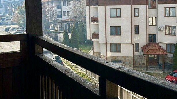 Blick von einem Balkon auf ein Wohngebiet mit einem Gebirge im Hintergrund.