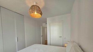Ein Schlafzimmer mit einem Bett, einer Hängelampe und einer Tür.