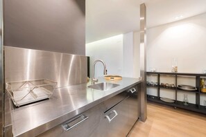 A modern kitchen with stainless steel appliances, a sink, and a wire basket on the counter. - The Double Loft | Designer Loft for 4 Next to Atocha (Madrid)
