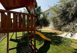 A wooden play structure with a slide in a backyard. - Primavera Villa - 2 Heated Pools & Jacuzzis (Pagkalochori)