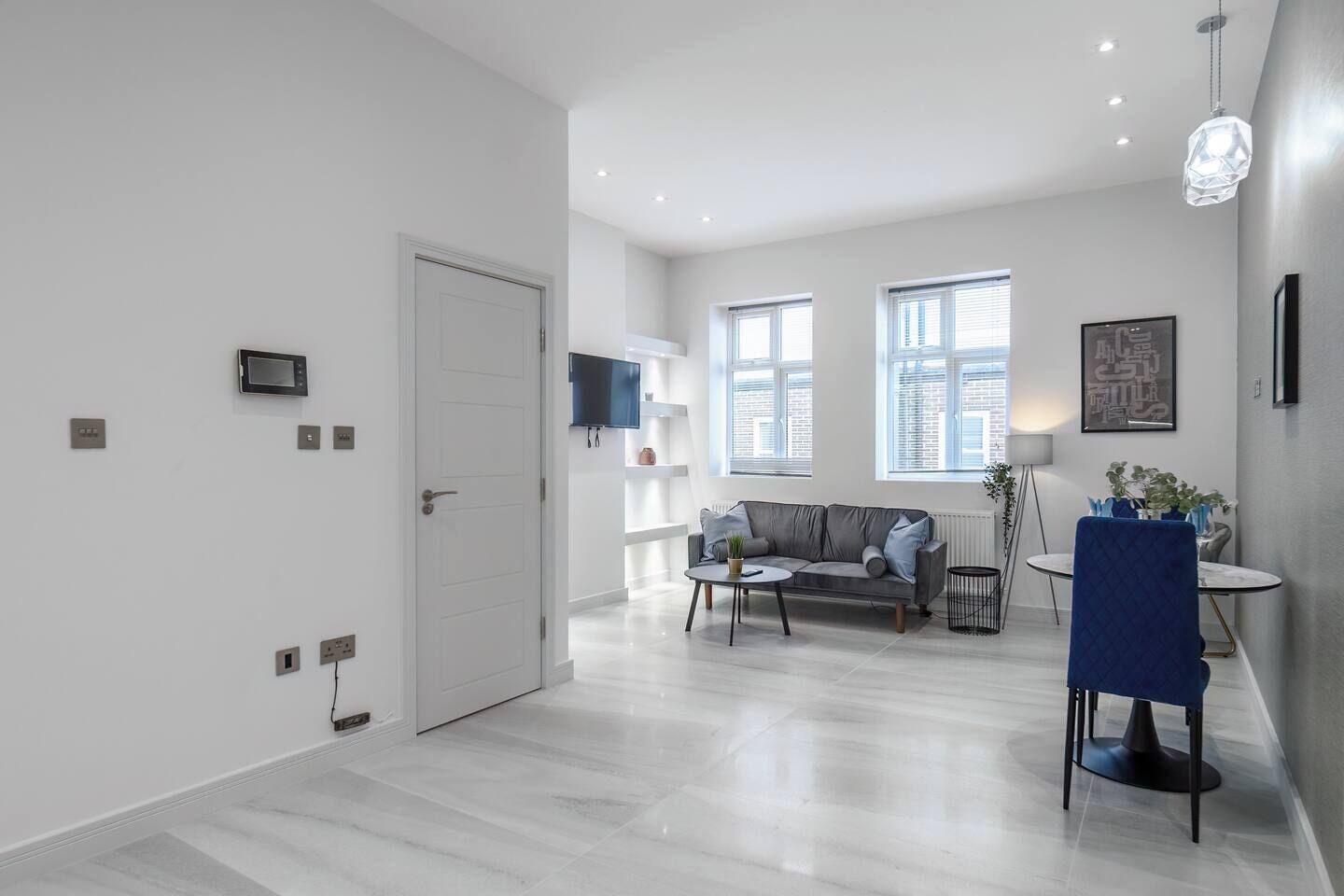 Una sala de estar moderna con un sofá, una mesa de centro y un comedor con una silla.