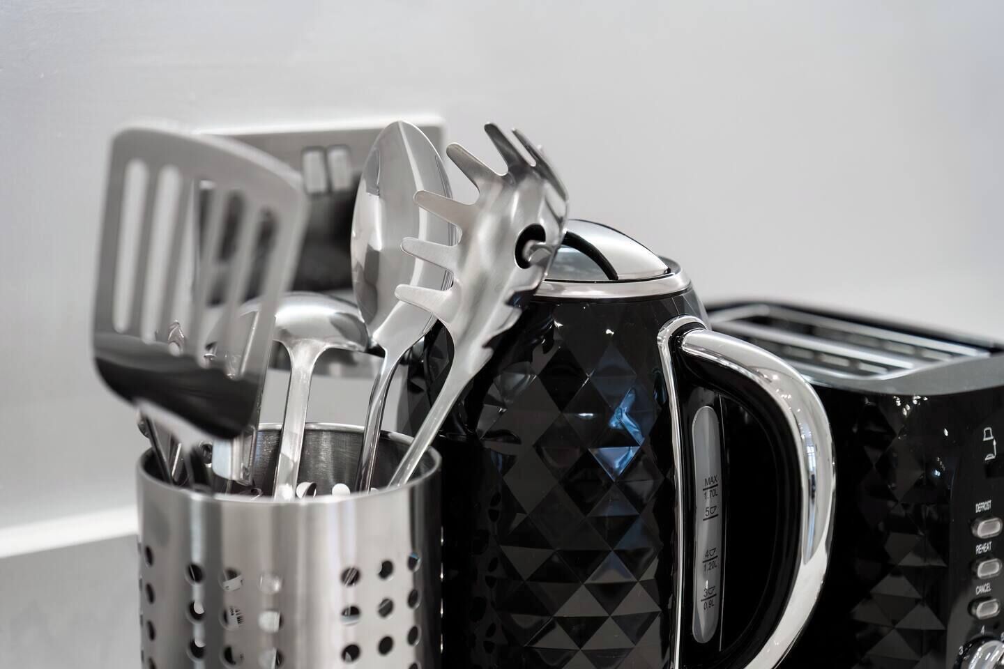 A kitchen utensil holder with various utensils, including a spatula and a ladle.