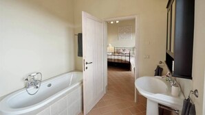 Ein Badezimmer mit Badewanne, Waschbecken und Spiegel.