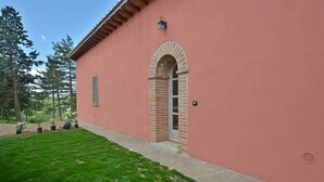 Un bâtiment doté d’une entrée en arc en briques, d’un petit porche et d’une pelouse bien entretenue.