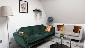 A modern living room with a green sofa, a white sofa, and a round coffee table. - Contemporary 2 Bed Apt in Didcot (Sleeps 7) (Didcot)