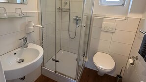 A modern bathroom with a glass-enclosed shower, a white sink, and a toilet. - Enchanting apartment "Schneewittchen" - Live at the Silbersee Frielendorf. (Frielendorf)