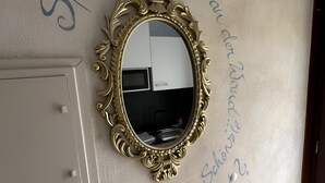 A wall with a decorative mirror and handwritten text in German. - Enchanting apartment "Schneewittchen" - Live at the Silbersee Frielendorf. (Frielendorf)