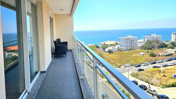 Uma varanda com vista para o mar e edifícios.