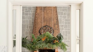 An open doorway leading to a dining area with a brick fireplace, a wooden table, and four chairs. - Casa dos Limões - Oeste (Bombarral)