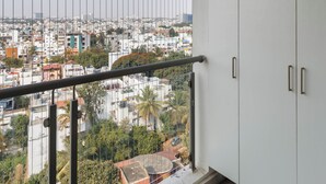 Un balcone con vista sulla città, un corrimano e pensili bianchi.