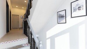 A staircase with a decorative railing and a framed picture of a bridge on the wall. - Calcutta Heritage by Jadecaps Shyambazar 2BK (Kolkata)