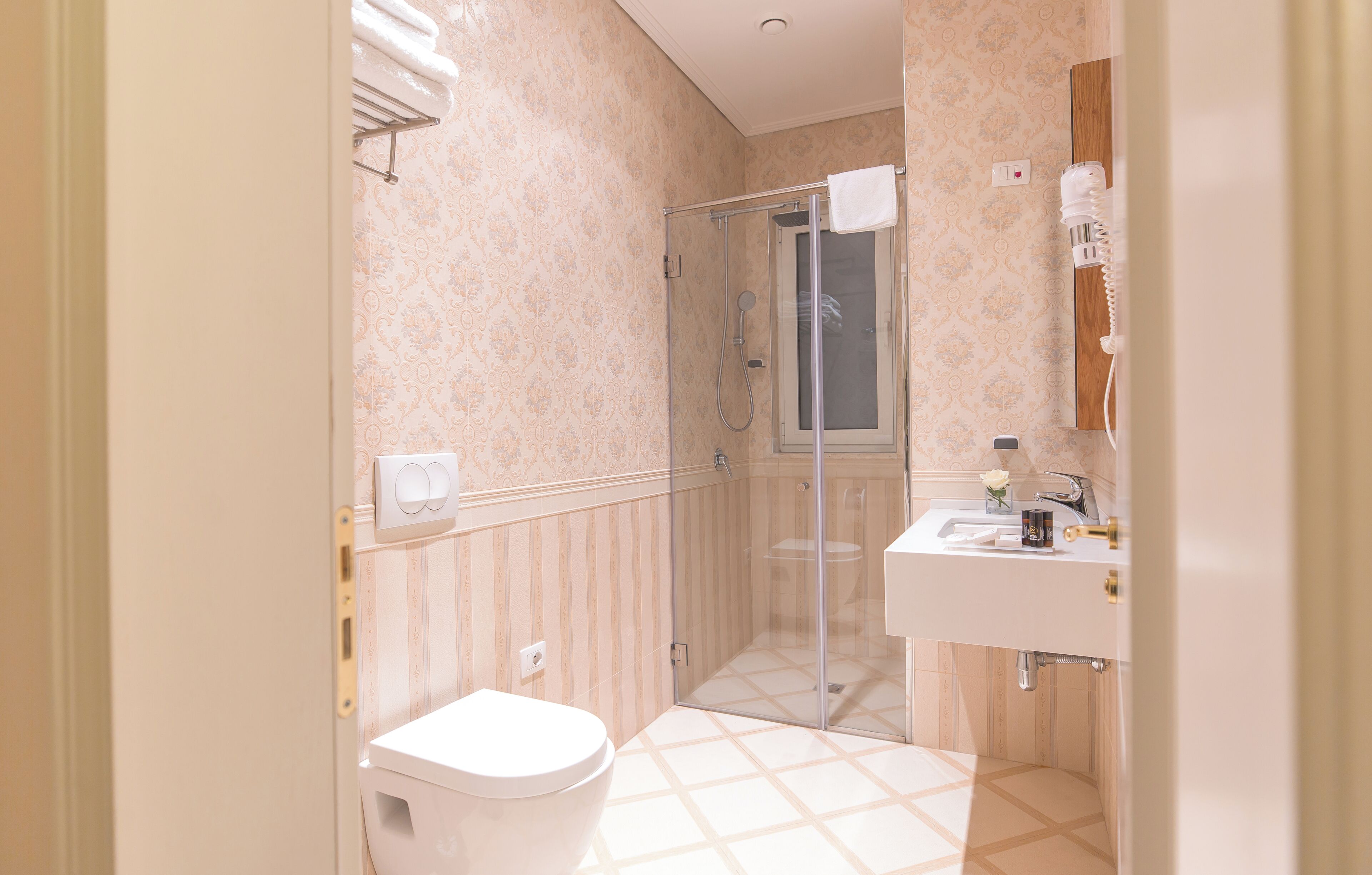 Une salle de bain avec des toilettes, un lavabo et une douche.